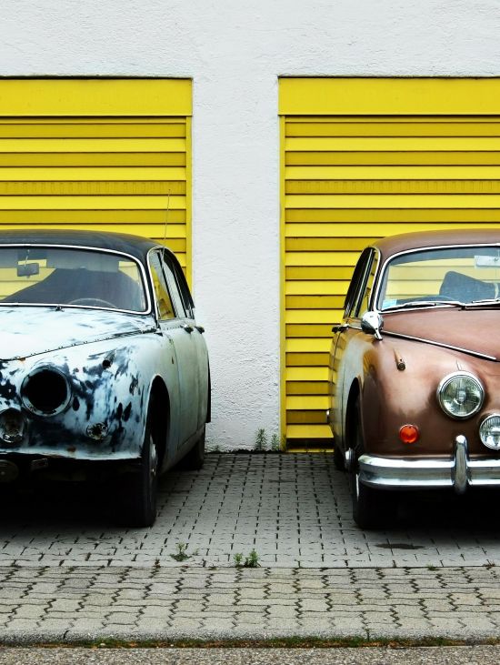 two cars side by side, one broken down and one freshly restored