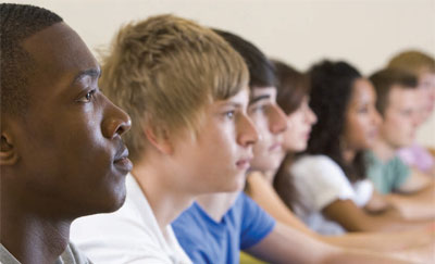 Success Boston students sitting at a table, looking forward,