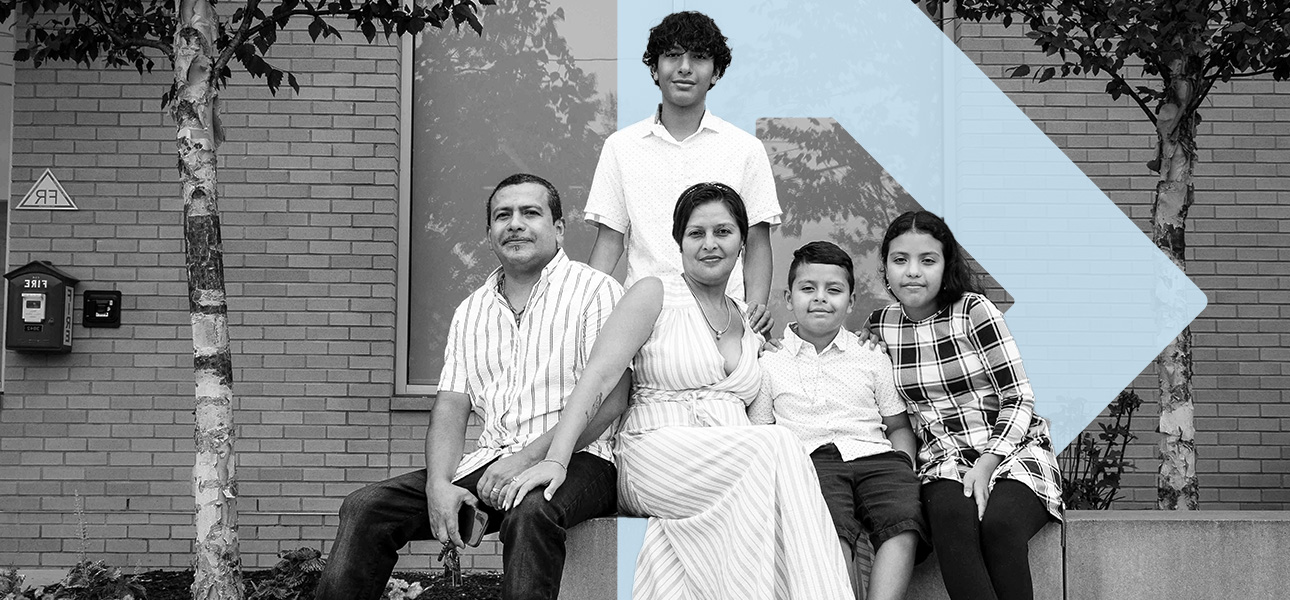 A black and white photo of a Latino family, a mother, father, and three children. They sit on a bench in front of a brick building. Layered behind the family is the light blue TBF arrow icon