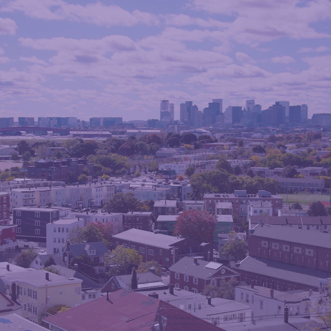 A view overlooking a Boston neighborhood with the downtown skyline in the background