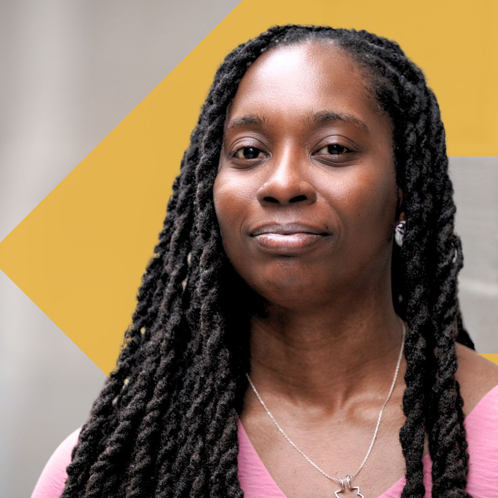 Candace Burton poses for a photo with a serious expression on her face, the orange TBF arrow icon is behind her in the photo.