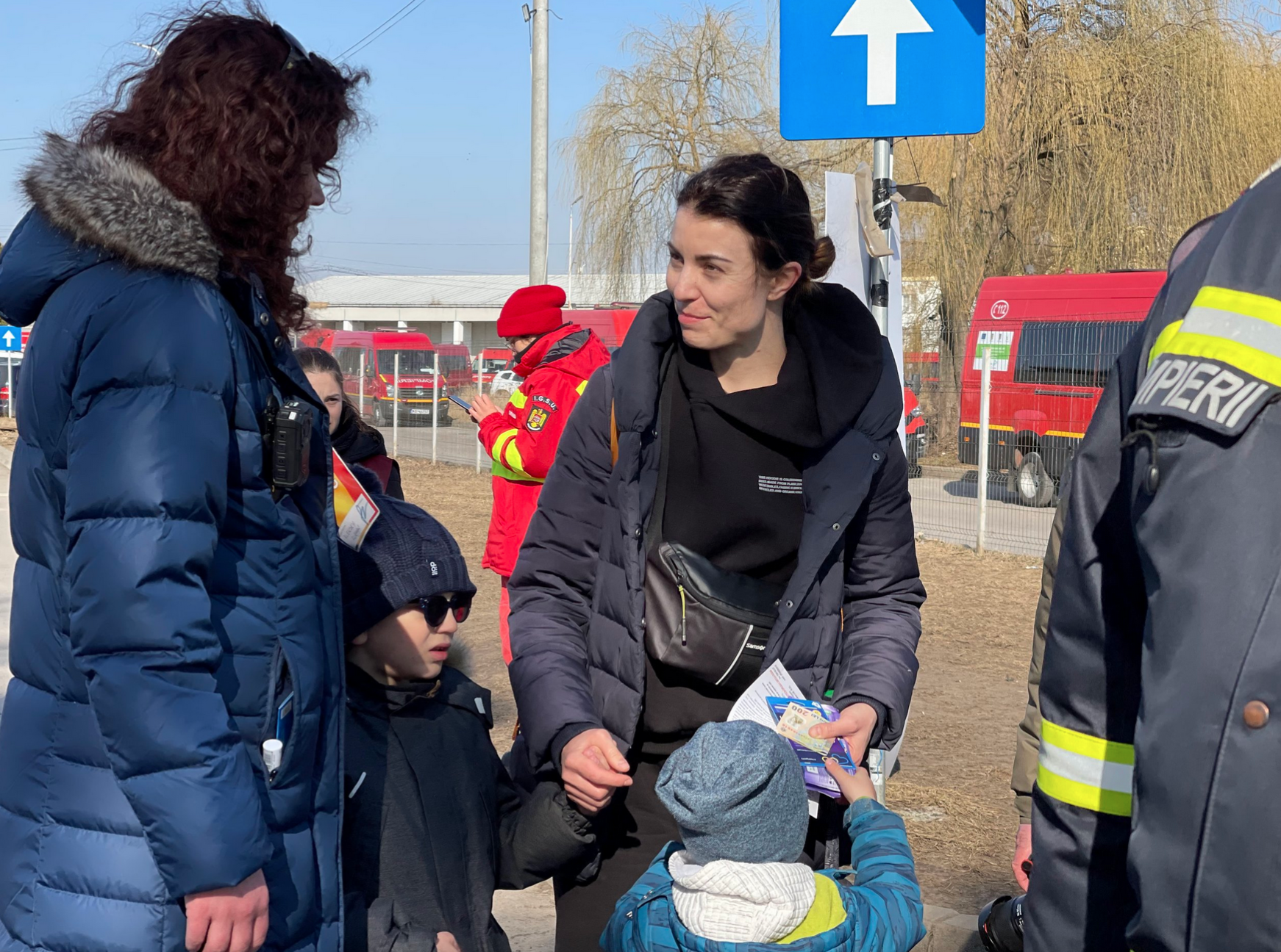 Cash For Refugees volunteer gives cash to Ukrainian mother with two kids at Romanian border