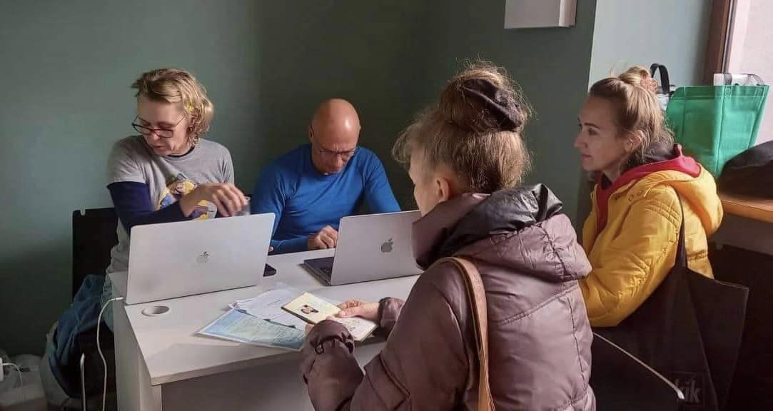 Natasha and Semyon Dukach at laptops process direct assistance grants to displaced Ukrainians