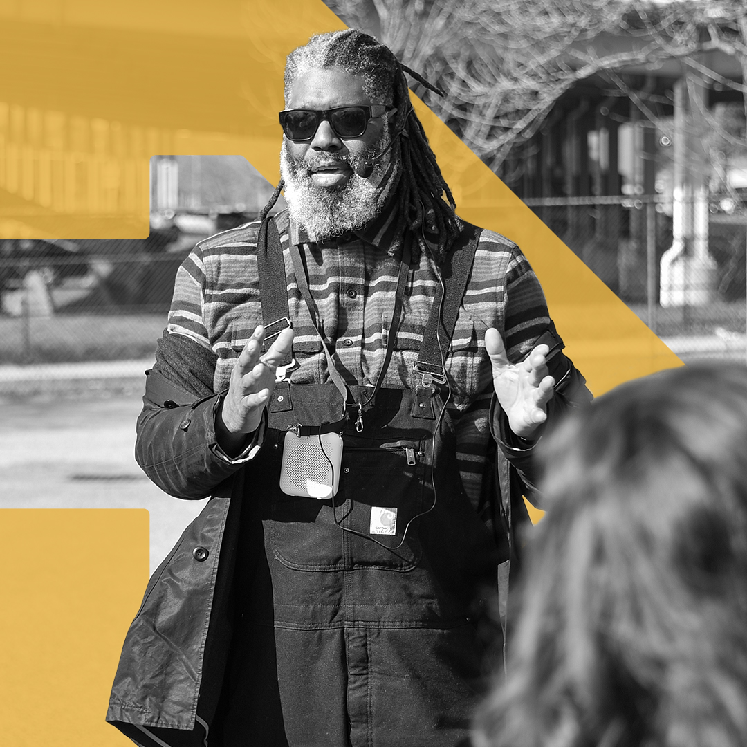 Dwaign Tyndal stands in a parking lot facing a group of people who are not seen in the photo.