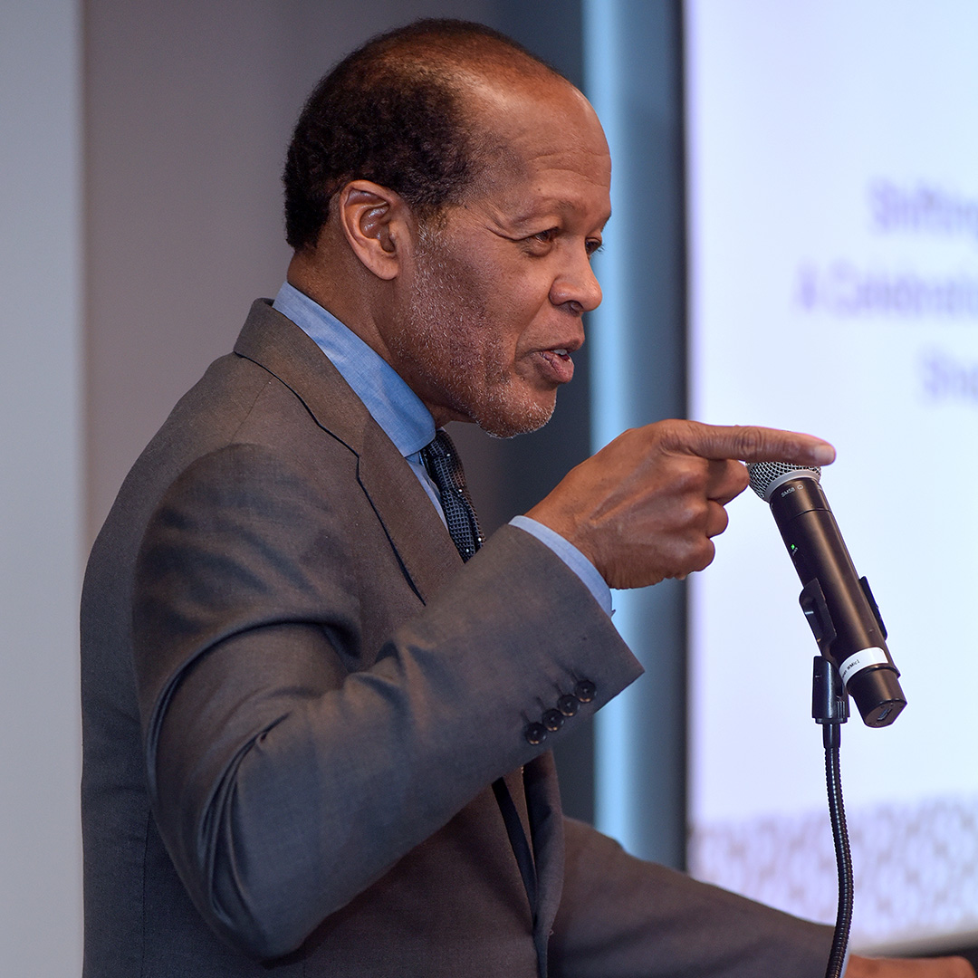 Lee Pelton stands at a lectern giving remarks at a TBF event