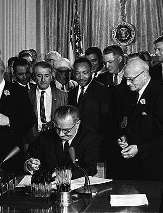 LBJ signs voting rights act as many look on including MLK