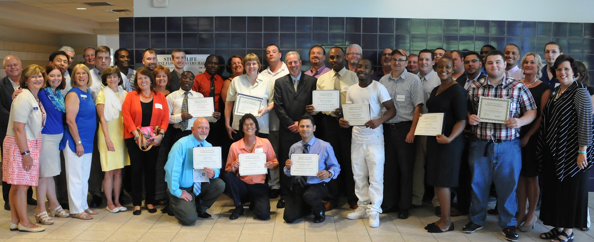 A group of people from North Shore Community College, some in the front row holding Deval Patrick Prize for Community Colleges certificates.