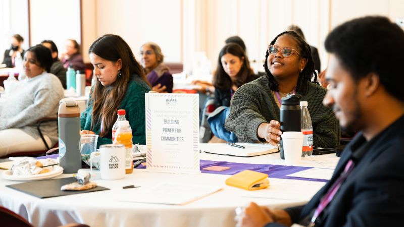 Smiling attendees around a table.
