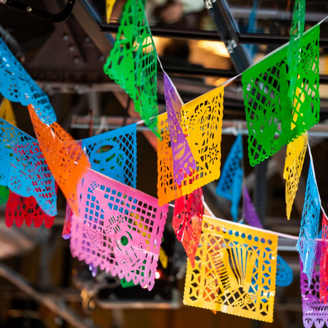 Colorful paper banners hang at the ceiling of an event venue.