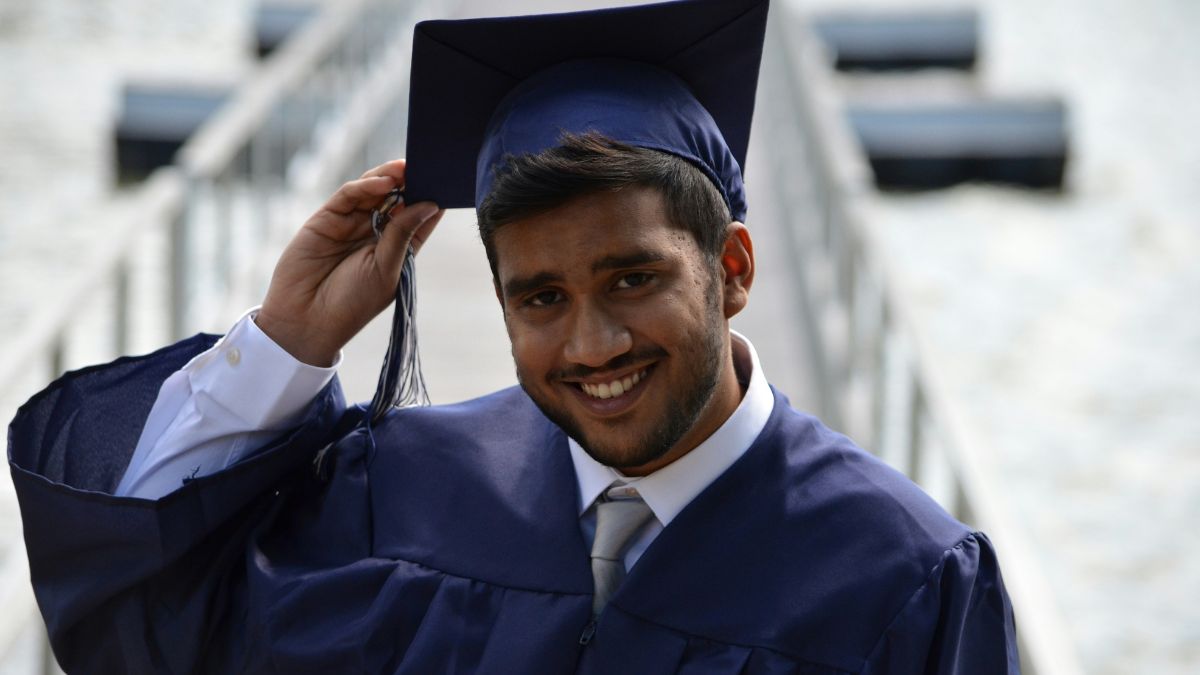 A young man at graduation wear a cap and gown
