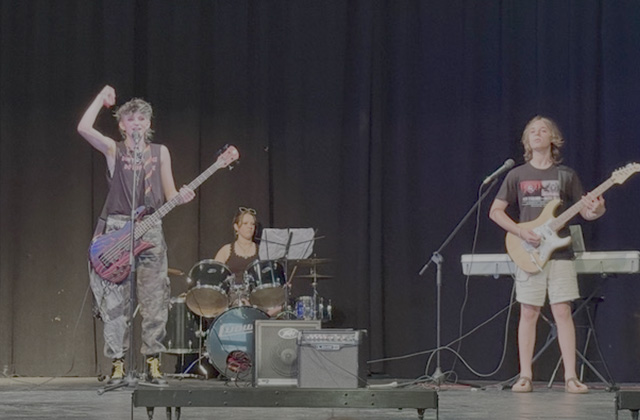 Campers perform onstage in a band