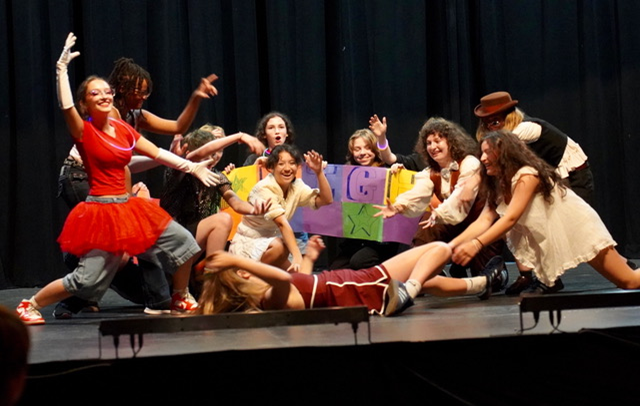 A group of kids perform onstage at camp