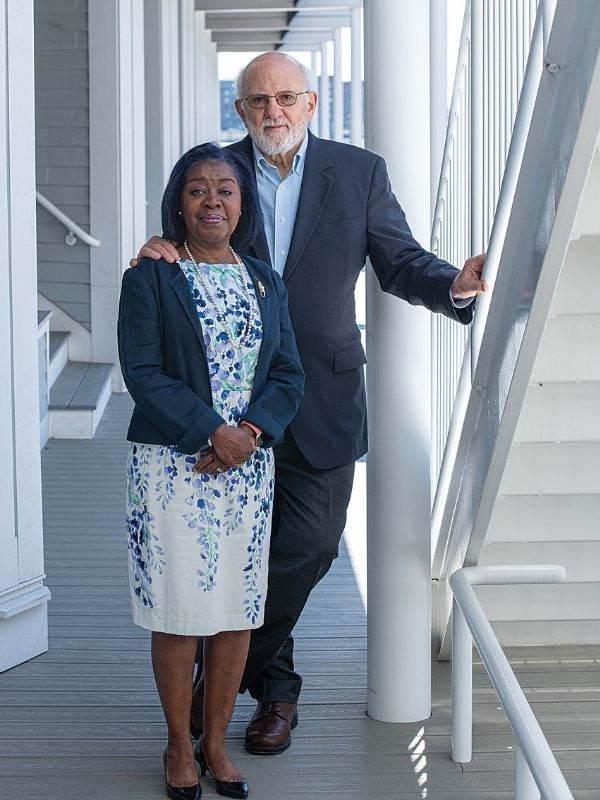 Dain (right) and Constance (left) Perry standing next to each other outside on a porch.
