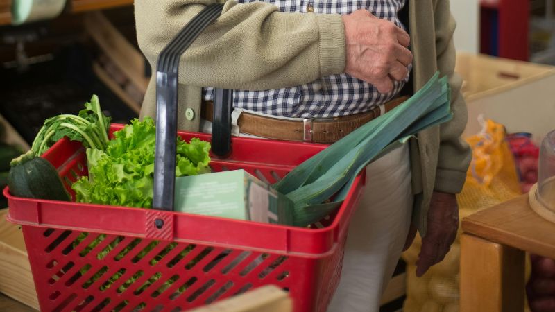 A man holds a grocery basket.