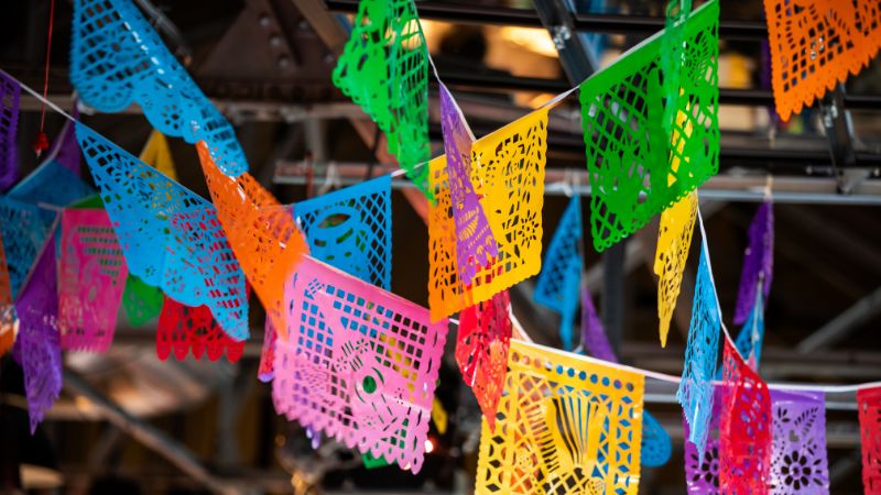 Colorful paper banners hang at the ceiling of an event venue.