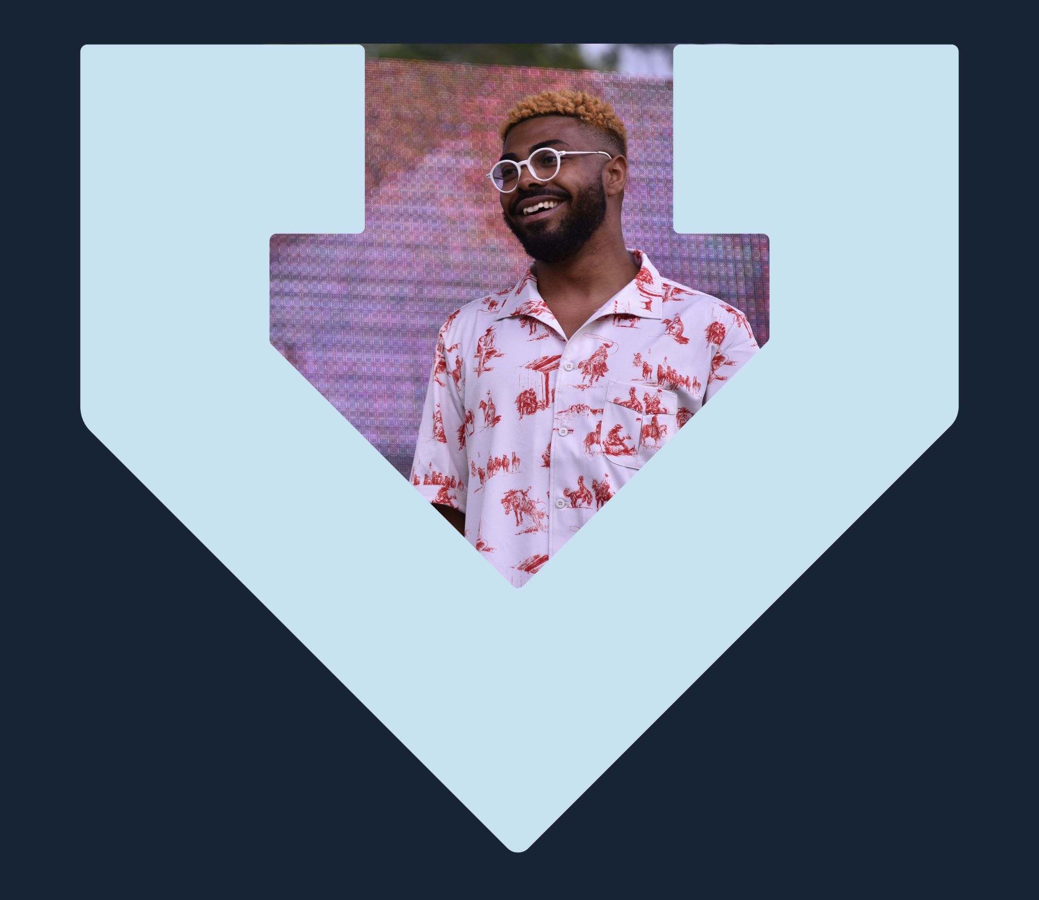 A Black man is looking off to the side and smiling, the photo is framed by the light blue TBF arrow