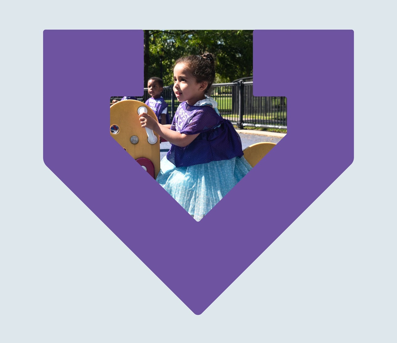 A young girl sits on a rocking horse outside on a playground framed by the purple TBF arrow