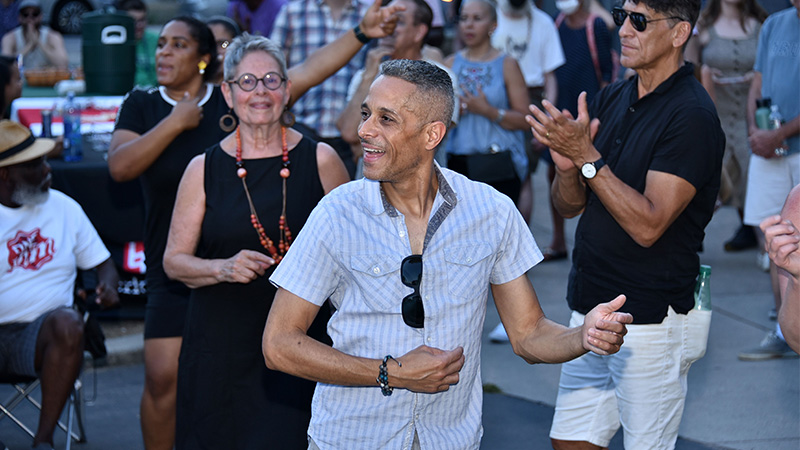 A man dances in a crowd at a street festival